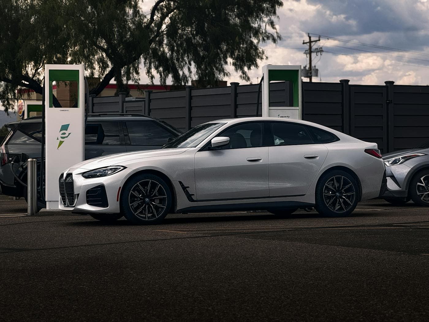 White BMW i4 charging at a public station